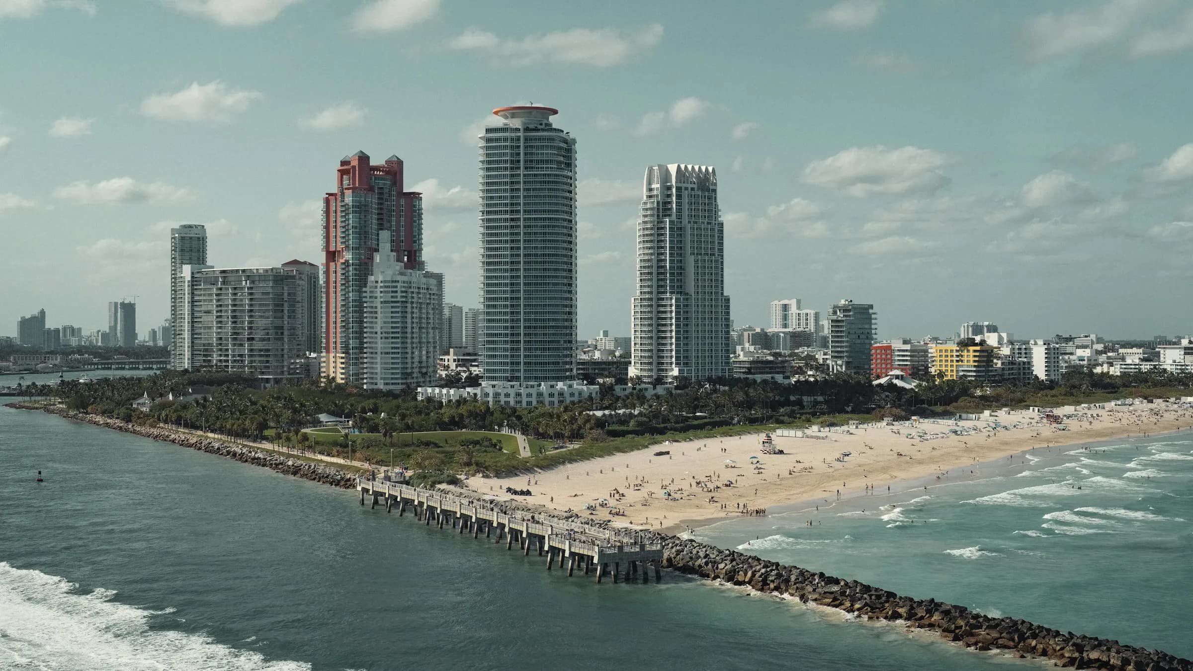 Havadan Miami South Beach: kıyı boyunca uzanan gökdelenler, dalgakıran ve turkuaz deniz.