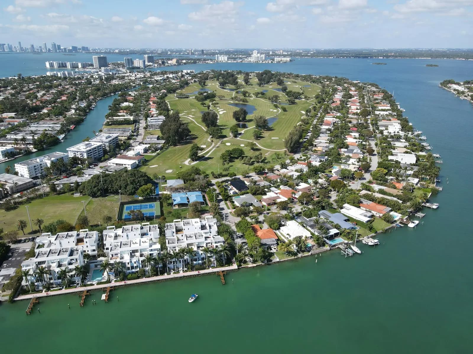 Havadan Miami Beach’te bir konut adası: ortasında golf sahası, çevresinde kanallar ve evler.