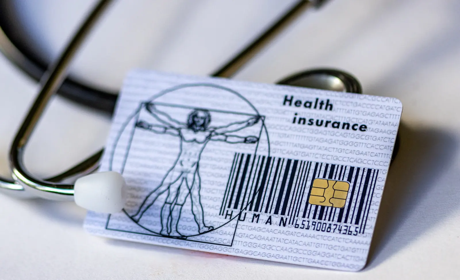 Üzerinde “Health insurance” yazan bir sağlık sigortası kartı ve yanında steteskop.