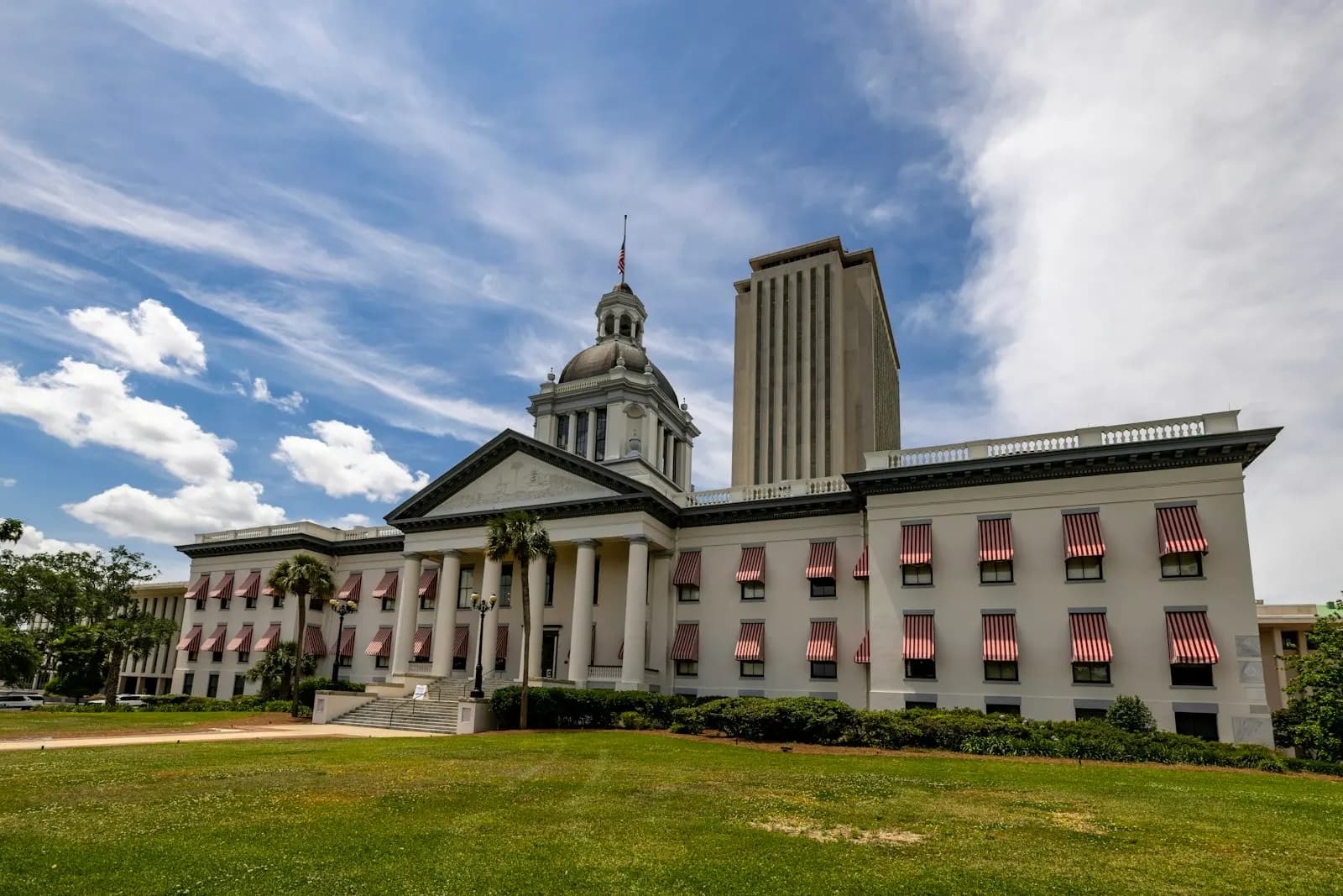 Tallahassee’deki tarihî Florida eyalet meclis binası; kırmızı-beyaz çizgili tenteleri ve arkasında yeni meclis kulesi.